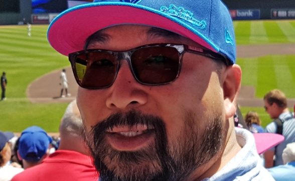 A bearded man wearing sunglasses and a Blue Jays baseball hat.